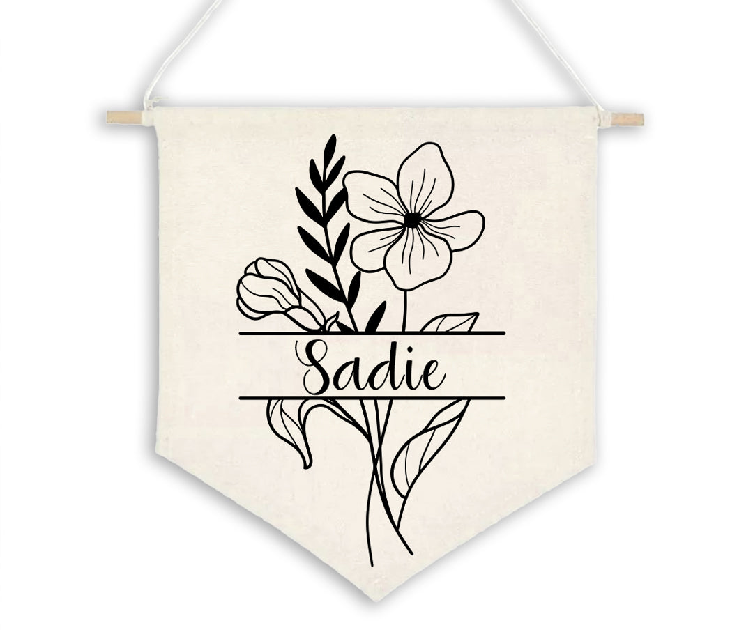 Birth Flower Name Flag made of natural white cotton, displaying the name 'Sadie' with the February birth flower, violet, split on either side of the name. The flag is shown against a plain background.