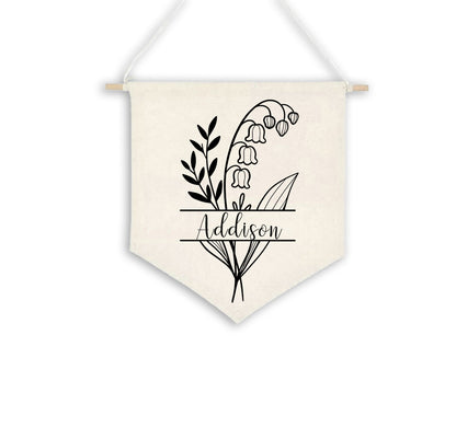 Birth Flower Name Flag made of natural white cotton, displaying the name 'Addison' with the May birth flower, lily of the valley , split on either side of the name. The flag is shown against a plain background.