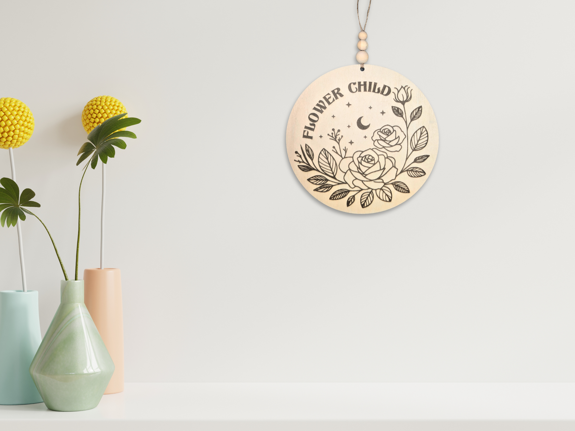 Wooden sign reading 'Flower Child' with floral details, positioned on a wall next to a vase of flower and foliage elements, adding a cheerful and vibrant touch to the room.