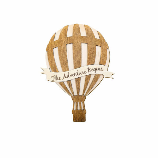 Whimsical Hot Air Balloon Milestone plaque featuring an engraved, interchangeable banner reading 'The Adventure Begins,' displayed on its own against a plain background.