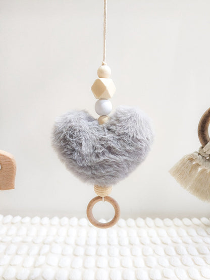 The wooden elephant macrame toy suspended from the baby gym, featuring wooden beads and ring.