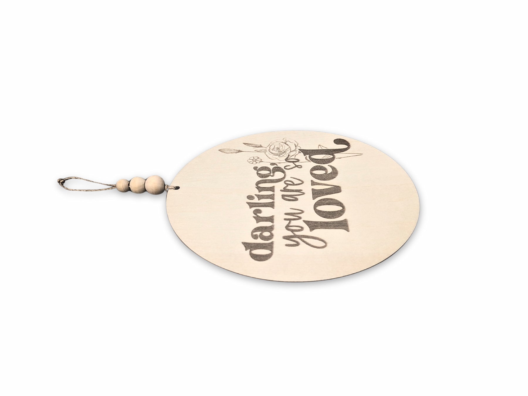 Side view of the 'Darling, You Are So Loved' wooden sign, showcasing its craftsmanship and natural wood texture, perfect for inspiring love and comfort in a child's space.